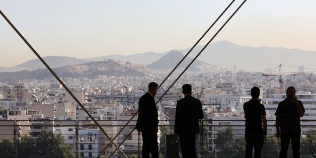 People look over the city of Athens from the terrace of the Stavros Niarchos Foundation on September 8, 2017, in Athens. / AFP PHOTO / LUDOVIC MARIN (Photo credit should read LUDOVIC MARIN/AFP/Getty Images)