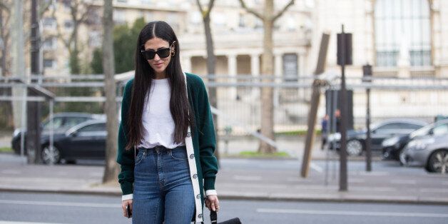 Designer Gilda Ambrosio wears black sunglasses, green cardigan, white top, high-waisted jeans, and and a black Chanel bag at the Ellery show at Palais de Tokyo on March 07, 2016 in Paris, France.
