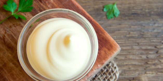 Mayonnaise sauce over rustic wooden background