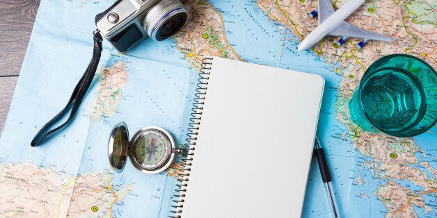 travel tourism agency table mockup tools compass, glass of water note pad, pen and toy airplane and touristic map on wooden table. Empty space you can place your text or information.