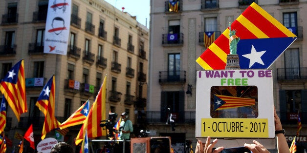 BARCELONA, SPAIN - SEPTEMBER 16: People hold up a replica of a ballot box with a Statue of Liberty with a Catalan flag ribbon next to a Catalan Pro-Independece flag during a demonstration of Catalan Mayors backing Independence Referendum on September 16, 2017 in Barcelona, Spain. 712 Catalan mayors who have backed the independence referendum were summoned by Spain's State Prosecutor over the independence vote, threatening arrests over non-cooperation. The vote on breaking away from Spain was called by the Catalan government for October 1, 2017 but was suspended by the Spanish Constitutional Court following a demand from the Spanish Government. Catalan and Spanish security forces have been instructed by Spain's Public Prosecutor's Office to take all the elements which could promote or help to celebrate the referendum. This includes ballots, ballots boxes and promotional material. (Photo by Sandra Montanez/Getty Images)