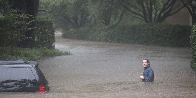 HOUSTON, TX - AUGUST 27: A resident walks down a flooded street in the upscale River Oaks neighborhood after it was inundated with water from Hurricane Harvey on August 27, 2017 in Houston, Texas. Harvey, which made landfall north of Corpus Christi late Friday evening, is expected to dump upwards to 40 inches of rain in Texas over the next couple of days. (Photo by Scott Olson/Getty Images)