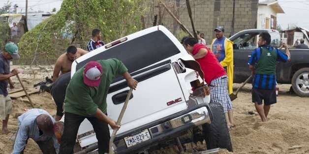 Men attemp to rescue a truck trapped following heavy rains caused by tropical storm Lidia in Los Cabos, Baja California, Mexico on September 1, 2017.At least four people were killed in the Mexican state of Baja California Sur (northwest) by the passage of tropical storm Lidia, which caused heavy rainfall and severe damage to roads, homes and basic services, the state government said. / AFP PHOTO / FERNANDO CASTILLO (Photo credit should read FERNANDO CASTILLO/AFP/Getty Images)