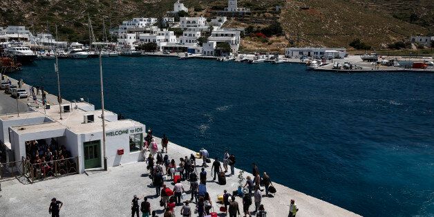 Tourists and passengers disembark from a passenger ferry as it arrives at port on the Aegean island of Ios, Greece, on Wednesday, May 20, 2015. The total level of aid available has risen by more than 20 billion euros since February, when the ECB locked Greek banks out of regular refinancing operations. Photographer: Yorgos Karahalis/Bloomberg via Getty Images