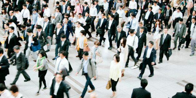 A busy pedestrian walkway, businessmen and women, walking to work, motion blurred, Tokyo. Daytime, horizontal composition.