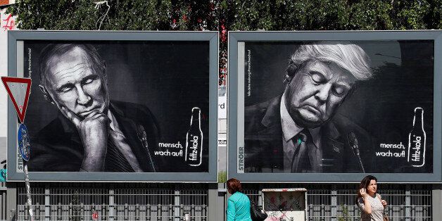 People walk past advertising posters of a German soft drink producer depicting Turkey's President Tayyip Erdogan, Russian President Vladimir Putin and U.S. President Donald Trump during the G20 summit in Hamburg, Germany, July 6, 2017. REUTERS/Fabrizio Bensch