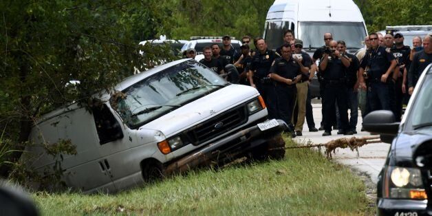 Police investigators watch as the van containing the six members of the the Saldivar family who died is towed to the road after they crashed their van into Greens Bayou as they tried to flee Hurricane Harvey during heavy flooding in Houston, Texas on August 30, 2017. / AFP PHOTO / MARK RALSTON (Photo credit should read MARK RALSTON/AFP/Getty Images)
