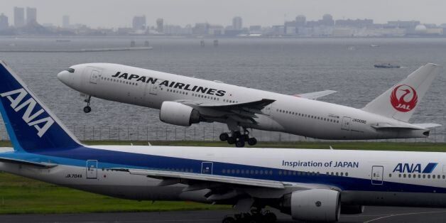 A Japan Airlines (JAL) Boeing 777 jetliner takes off beside All Nippon Airways (ANA) jetliner at Haneda international airport in Tokyo on August 2, 2017. / AFP PHOTO / Toshifumi KITAMURA (Photo credit should read TOSHIFUMI KITAMURA/AFP/Getty Images)