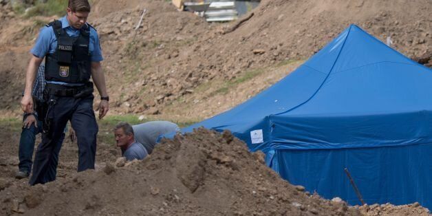 A policeman walks past a blue tent covering a British World War II bomb that was found during construction works on August 30, 2017 in Frankfurt am Main, western Germany.The disposal of the bomb that is planned for Sunday, September 3, 2017 requires the evacuation of around 70,000 people. / AFP PHOTO / dpa / Boris Roessler / Germany OUT (Photo credit should read BORIS ROESSLER/AFP/Getty Images)