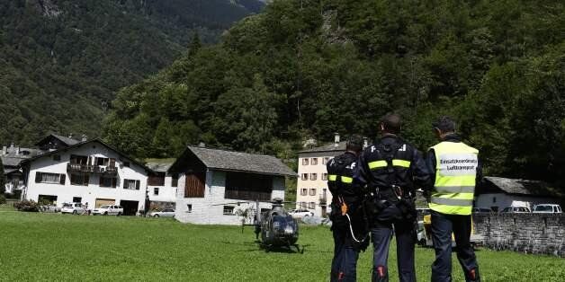 Swiss police officers gather on August 24, 2017 where a landslide struck during the night of August 23 in the village of Bondo, Switzerland. Eight hikers are missing after a massive landslide swept away an entire mountainside in the Swiss Alps, ripping apart buildings and forcing the evacuation of a village, police said on August 24, 2017. The landslide, which struck on August 23, sent mud, rocks and dirt flooding down the Piz Cengalo mountain into the outskirts of the village of Bondo, near the