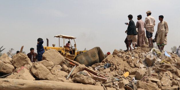 People stand on the debris of a house at the site of a Saudi-led air strike on an outskirt of the northwestern city of Saada, Yemen August 4, 2017. REUTERS/Naif Rahma