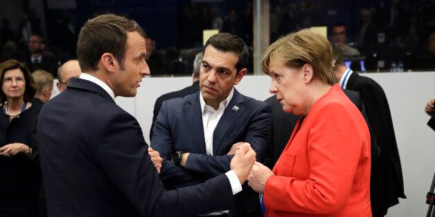 (L-R) French President Emmanuel Macron, Greek Prime Minister Alexis Tsipras and German Chancellor Angela Merkel speak during a workking dinner at the NATO (North Atlantic Treaty Organization) summit at the NATO headquarters, in Brussels, on May 25, 2017. / AFP PHOTO / POOL / Matt Dunham (Photo credit should read MATT DUNHAM/AFP/Getty Images)