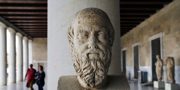 An ancient marble head of Greek historian Herodotus is seen as tourists walk through the Attalos arcade in Athens February 26, 2015. Greece's economy is expected to grow this year but faces risks from the government's ability to fulfill a deal with the euro zone and reform fatigue, central bank governor Yannis Stournaras said in his annual report published on Thursday. The arcade was erected by Attalos II King of Pergamon 159-138 BC and the building was reconstructed by the American school of classical studies in Athens under the authority of the Greek Ministry of Education in the reign of King Paul in 1953-1956. REUTERS/Yannis Behrakis (GREECE - Tags: POLITICS BUSINESS TRAVEL)