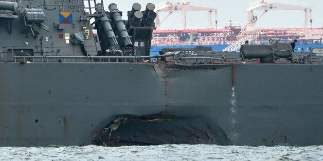 A general view shows the guided-missile destroyer USS John S. McCain with a hole on its left portside after a collision with oil tanker, outside Changi naval base in Singapore on August 21, 2017.Ten US sailors were missing and five injured early on August 21 after their destroyer collided with a tanker east of Singapore, the second accident involving an American warship in two months. / AFP PHOTO / ROSLAN RAHMAN (Photo credit should read ROSLAN RAHMAN/AFP/Getty Images)