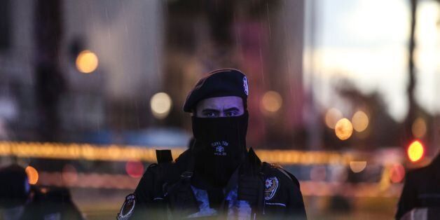 A Turkish police officer stands guard at the site of an explosion in front of the courthouse in Izmir on January 5, 2017. A car bombing rocked the Turkish city of Izmir on January 5, 2016, killing at least two people and triggering a shootout that left two suspected militants dead, as authorities chased the fugitive killer behind the New Year attack in Istanbul. / AFP / EMRE TAZEGUL (Photo credit should read EMRE TAZEGUL/AFP/Getty Images)
