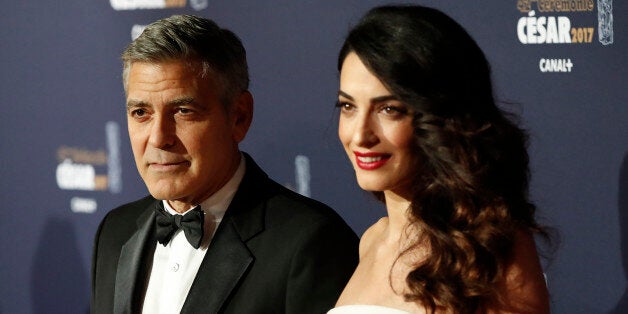 Actor George Clooney and his wife Amal pose as they arrive at the 42nd Cesar Awards ceremony in Paris, France, February 24, 2017. REUTERS/Gonzalo Fuentes