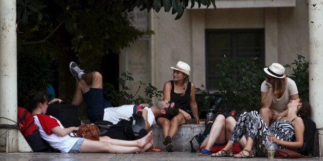Tourists relax under trees in central Athens, Greece August 4, 2015. Southeastern Europe and the Middle East region have been affected by higher-than-normal temperatures in recent days. REUTERS/Yiannis Kourtoglou