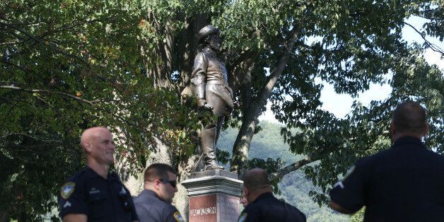 Police officers stand around a statue of Confederate general Thomas J.