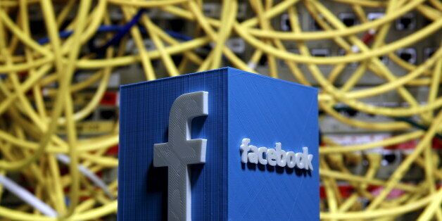 A 3D plastic representation of the Facebook logo is seen in front of displayed cables in this illustration in Zenica, Bosnia and Herzegovina May 13, 2015. Facebook announced deals with nine publishers -- including NBC News, the New York Times and BuzzFeed -- to deliver select articles