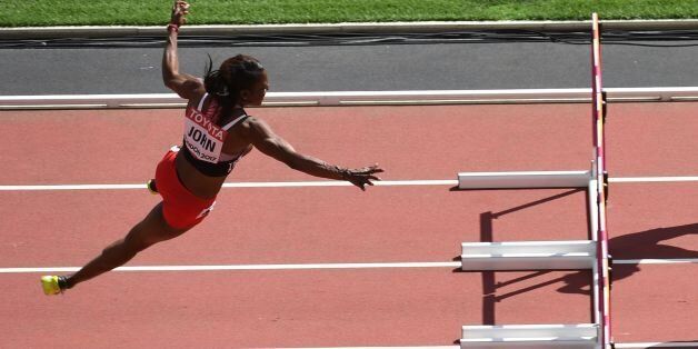 Trinidad and Tobago's Deborah John (L) falls as she competes in the women's 100m hurdles athletics event at the 2017 IAAF World Championships at the London Stadium in London on August 11, 2017. / AFP PHOTO / Glyn KIRK (Photo credit should read GLYN KIRK/AFP/Getty Images)