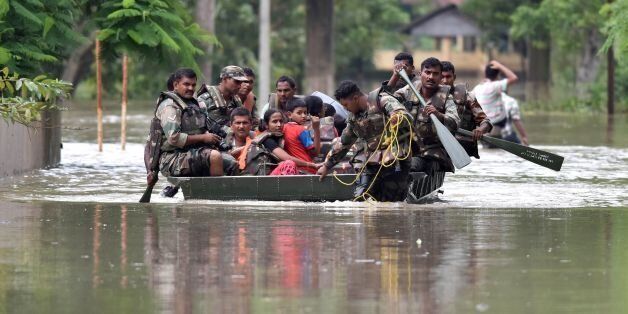 Indian army soldiers evacuate villagers in the flood affected Jakhalabandha area in Koliabor, some 186km from Guwahati, the capital city of Indias northeastern state of Assam on August 13, 2017. / AFP PHOTO / Biju BORO (Photo credit should read BIJU BORO/AFP/Getty Images)