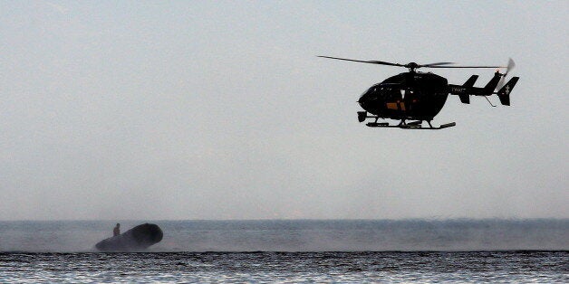 A Frontex helicopter stops a dinghy with a suspected smuggler off the Greek island of Lesbos September 24, 2015. According to witnesses, earlier the dinghy ferried Afghan migrants on a beach in Lesbos. On its way back to Turkish coast, the suspected smuggler was stopped by a Frontex chopper and arrested by the crew of a Greek Coast Guard vessel. REUTERS/Yannis Behrakis