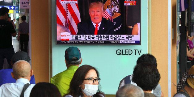 People watch a television news programme showing US President Donald Trump at a railway station in Seoul on August 9, 2017.President Donald Trump issued an apocalyptic warning to North Korea on Tuesday, saying it faces 'fire and fury' over its missile program, after US media reported Pyongyang has successfully miniaturized a nuclear warhead. / AFP PHOTO / JUNG Yeon-Je (Photo credit should read JUNG YEON-JE/AFP/Getty Images)