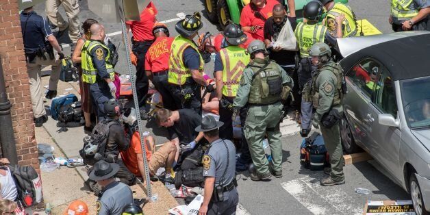 People receive first-aid after a car accident ran into a crowd of protesters in Charlottesville, VA on August 12, 2017. A picturesque Virginia city braced Saturday for a flood of white nationalist demonstrators as well as counter-protesters, declaring a local emergency as law enforcement attempted to quell early violent clashes. / AFP PHOTO / PAUL J. RICHARDS (Photo credit should read PAUL J. RICHARDS/AFP/Getty Images)