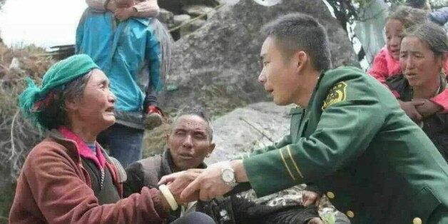 A paramilitary policeman (3rd R) speaks to a woman, after a 7.9 magnitude earthquake hit Nepal, in Xigaze Prefecture, Tibet Autonomous Region, China, April 25, 2015. Rescuers dug with their bare hands and bodies piled up in Nepal on Sunday after an earthquake devastated the heavily crowded Kathmandu valley, killing at least 1,900, and triggered a deadly avalanche on Mount Everest. In Tibet, the death toll climbed to 17, according to a tweet from China's state news agency, Xinhua. Picture taken April 25, 2015. REUTERS/Stringer QUALITY FROM SOURCE. CHINA OUT. NO COMMERCIAL OR EDITORIAL SALES IN CHINA