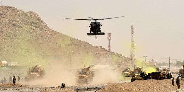 A US black hawk helicopter flies over the site of a Taliban suicide attack in Kandahar on August 2, 2017. A Taliban suicide bomber on August 2 rammed a vehicle filled with explosives into a convoy of foreign forces in Afghanistan's restive southern province of Kandahar, causing casualties, officials said. 'At around noon a car bomb targeted a convoy of foreign forces in the Daman area of Kandahar,' provincial police spokesman Zia Durrani told AFP. / AFP PHOTO / JAVED TANVEER (Photo credit