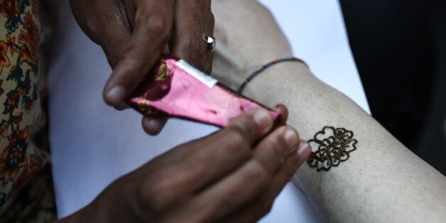MOSCOW, RUSSIA - AUGUST 12, 2017: Applying a henna tattoo during celebrations of India Day marking the 70th anniversary of the establishment of diplomatic relations between Russian and India, in Moscow's Sokolniki Park. Stanislav Krasilnikov/TASS (Photo by Stanislav Krasilnikov\TASS via Getty Images)