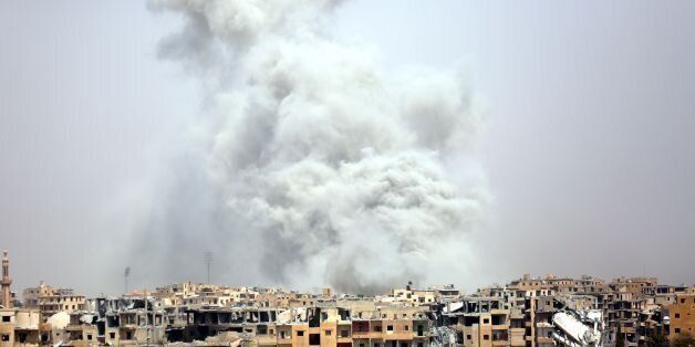 TOPSHOT - Smoke billows out from Raqa following a coalition air strike on July 28, 2017.The Syrian Democratic Forces, a US-backed Kurdish-Arab alliance, has ousted Islamic State (IS) group jihadists from half of their Syrian bastion Raqa, where the SDF have been fighting for several months to capture the northern city which has become infamous as the Syrian heart of IS's so-called 'caliphate.' / AFP PHOTO / DELIL SOULEIMAN (Photo credit should read DELIL SOULEIMAN/AFP/Getty Images)
