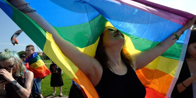 A woman holds the gay rights' movement rainbow flag during the gay pride rally in Saint Petersburg, on Agust 12, 2017. / AFP PHOTO / OLGA MALTSEVA (Photo credit should read OLGA MALTSEVA/AFP/Getty Images)