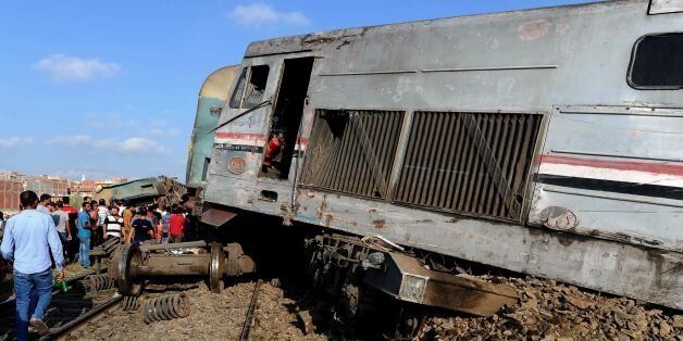 People gather at the site of a train collision in the area of Khorshid, in Egypts Mediterranean city of Alexandria, on August 11, 2017.At least 36 people were killed as two trains collided outside of Alexandria, in one of the deadliest in a string of such accidents in Egypt, the health ministry said. / AFP PHOTO (Photo credit should read /AFP/Getty Images)