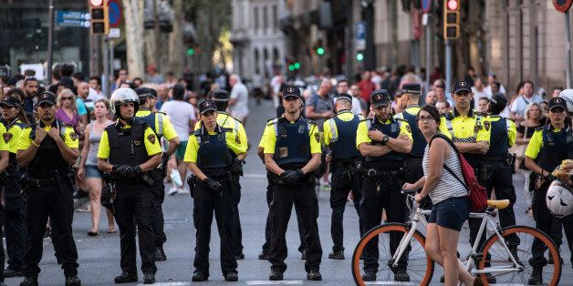 BARCELONA, SPAIN - AUGUST 18: A cyclist pushes her bike past a line of police officers on Las Ramblas near the scene of yesterday's terrorist attack, on August 18, 2017 in Barcelona, Spain. Fourteen people were killed and dozens injured when a van hit crowds in the Las Ramblas area of Barcelona on Thursday. Spanish police have also killed five suspected terrorists in the town of Cambrils to stop a second terrorist attack. (Photo by Carl Court/Getty Images)