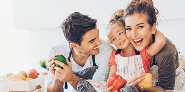 Young couple with small girl in the kitchen.