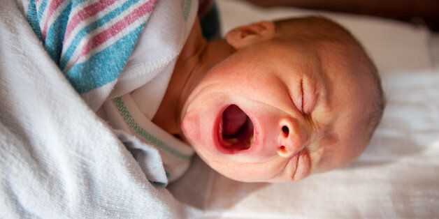 A 1 day old baby boy crying.