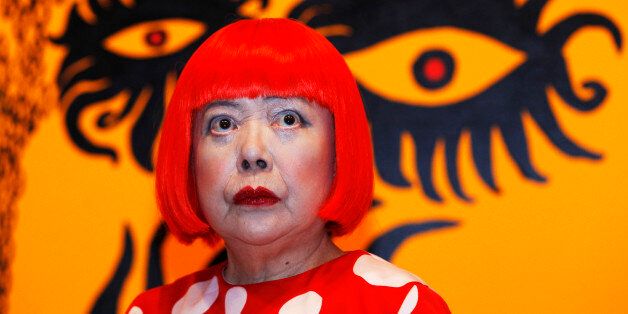 Artist Yayoi Kusama poses for a photograph with a detail from her artwork