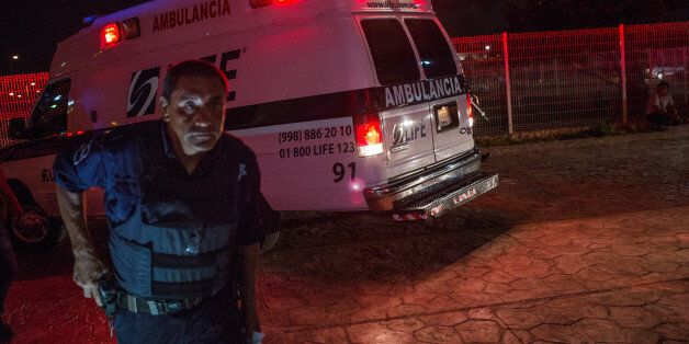 A police officer guards an ambulance carrying a shooting victim in front of the General Hospital in Cancun, Mexico, on Tuesday, July 11, 2017. The narco-traffickers already hold sway over swaths of Mexico, either co-opting state officials or openly defying them. Now they're encroaching on the country's spring-break meccas like never before, leaving bodies in suitcases outside exclusive condos, or shooting up nightclubs. Photographer: Brett Gundlock/Bloomberg via Getty Images