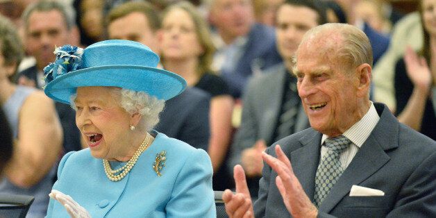 Britain's Queen Elizabeth (L) and and Prince Philip react as they listen to a school musical performance during a tour of Sydney Russell School in Dagenham, east London, July 16, 2015. The Queen and Prince Philip were visiting various parts of Barking and Dagenham as part of the celebrations to mark the fiftieth anniversary of the London Borough. REUTERS/Toby Melville