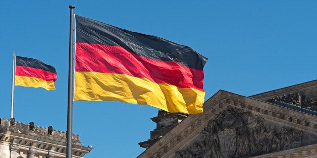 two Germany flags on top of the Reichstag