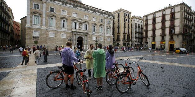 A guide speaks to his group during a bike tour at Sant Jaume square at Gothic quarter in Barcelona, Spain, August 18, 2015. Barcelona's new mayor is picking a fight with home rental websites as she tries to crack down on uncontrolled tourism that she fears could drive out poor residents and spoil the Catalan capital's charm. Picture taken on August 18, 2015. REUTERS/Albert Gea