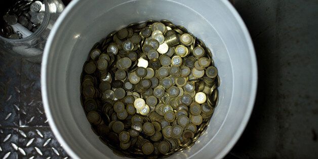 A bucket with Bolivar coins sits inside a market in Caracas, Venezuela, on Sunday, Oct. 16, 2016. Once one of the world's strongest currencies, the bolivar has been reduced to a nuisance. Basic purchases require hundreds of bills. The currency is so devalued and each purchase requires so many bills that instead of counting, businesses are weighing them. Photographer: Manaure Quintero/Bloomberg via Getty Images