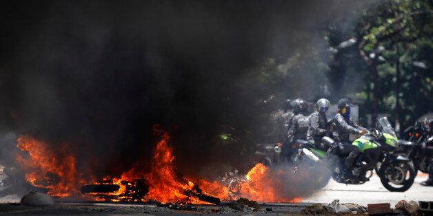 Security forces members ride near burning motorcycles as clashes break out while the Constituent Assembly election is being carried out in Caracas, Venezuela, July 30, 2017. REUTERS/Carlos Garcia Rawlins
