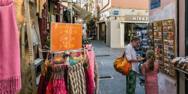 Chania, Crete, Greece - July 4, 2016: Tourists visit gift shops in Chania town on Crete island.