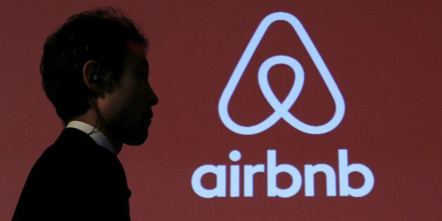 A man walks past a logo of Airbnb after a news conference in Tokyo, Japan, November 26, 2015. REUTERS/Yuya Shino/File Photo
