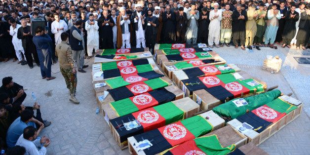 Afghan mourners offer funeral prayers near the coffins of victims following a mosque attack that killed 33 people in Herat on August 2, 2017. Thousands of Shiite protesters chanted slogans against the Islamic State group on August 2 as they carried the coffins of victims of a mosque attack that killed 33 people in the western Afghan city of Herat. / AFP PHOTO / HOSHANG HASHIMI (Photo credit should read HOSHANG HASHIMI/AFP/Getty Images)