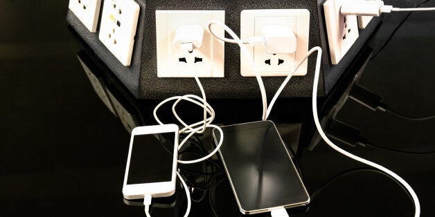 Charging station for mobile smart phones at international airport - Helpful corner for electronical modern technology devices and smartphones