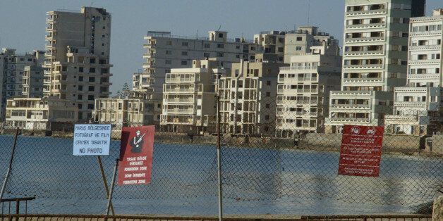A view of the ghost town of Famagusta is seen in northern Cyprus, May 2, 2003. Cyprus has been ethnically separated since Turkey invaded on July 20, 1974, and seized the northern third of territory, five days after a Greek Cypriot coup aimed at union with Greece. Barbed wire and concrete-filled oil drums surround Maria Riri Myles' family apartment in a snake- and rat-infested no-go zone of northern Cyprus occupied only by patrolling Turkish soldiers. But it still feels like home. Myles' hometown of Varosha, now an eerie collection of derelict high-rise hotels, churches and residences, once drew luxury-seeking Hollywood stars like Paul Newman and Elizabeth Taylor. Deserted since a 1974 war that split the island, it is now the ultimate bargaining chip in the decades-long stand-off between Greek Cypriots and Turkish Cypriots. Picture taken May 2, 2003. To match Feature CYPRUS-TOWN/TURKEY REUTERS/Andreas Manolis (CYPRUS - Tags: CITYSPACE SOCIETY)
