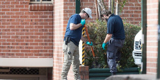 SYDNEY, NEW SOUTH WALES - JULY 30: Police officers search a garden bed of an apartment complex in Sproule Street, Lakemba, the scene of an overnight terror raid on July 30, 2017 in Sydney, Australia. Counter terrorism police raided four houses across Sydney on Saturday night and arrested four men over an alleged terror plot that involved blowing up an aircraft. Australian travellers have been warned to expect major delays at airports around the country with security screening measures ramped up following the raids. (Photo by Brook Mitchell/Getty Images)